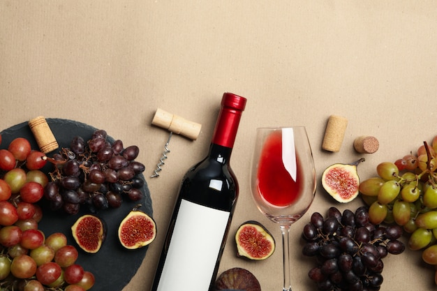 Composition with wine and fruits on craft background, space for text