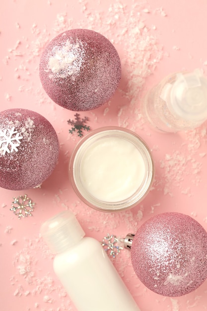 Composition with winter cosmetic products on pink background