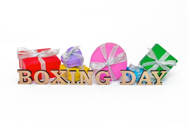 Composition with words BOXING DAY and many gift boxes, isolated on white