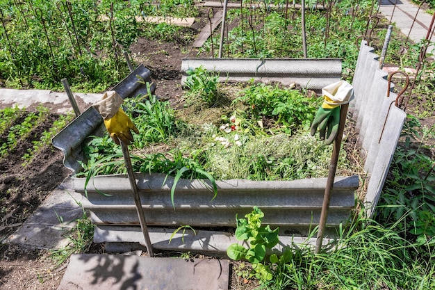 Компостная куча с растительными отходами для удобрения сада