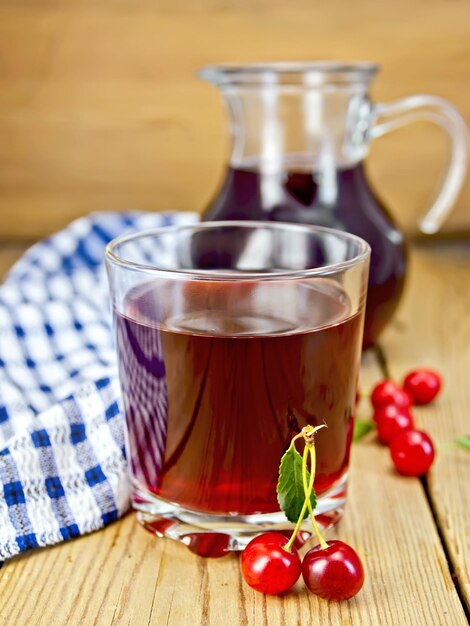 Compote cherry in glass jug on board