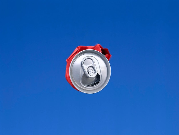 青い空を背景に空中で撮影された圧縮缶