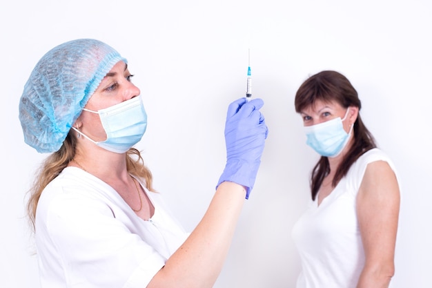 Compulsory vaccination of population female doctor or nurse holds syringe in hand to vaccinate patie...