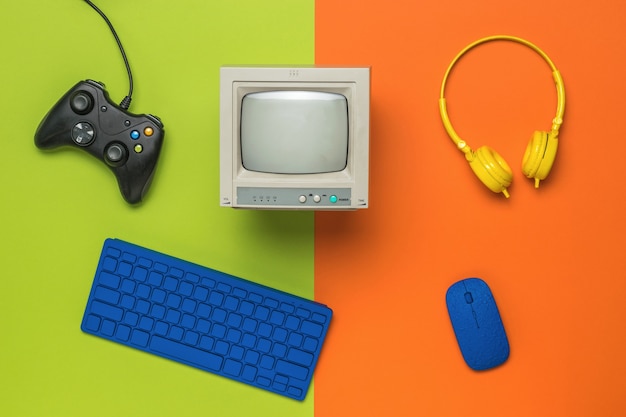 주황색 녹색 배경에 컴퓨터 액세서리와 게임 콘솔이 있습니다. 게임과 교육의 기술. 플랫 레이.