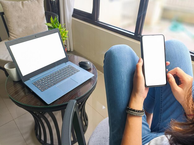 Computer blank screen phone mockup image with white background for advertising woman39s hand using laptop and mobile phone on table in cafemockup