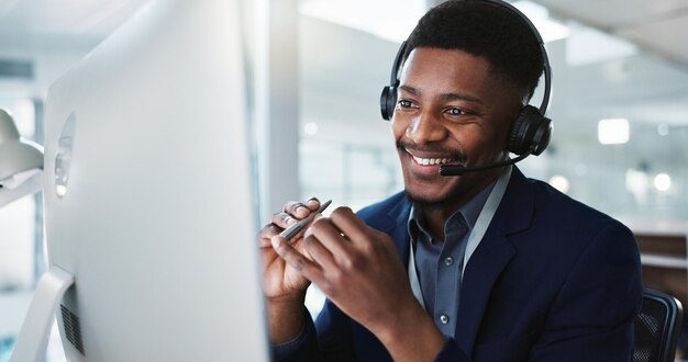 Computer call center and black man talking telemarketing and technical support at help desk communication customer service and happy sales agent consulting crm advisory and speaking to contact