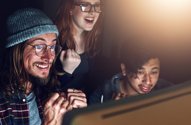 コンピューターの歓声と夜の人々は、ERP ソフトウェアのサイバーセキュリティの成功またはコードの完成を祝うチームワーク AI 開発者または興奮したプログラマーが機械学習データベースのコーディングを行う