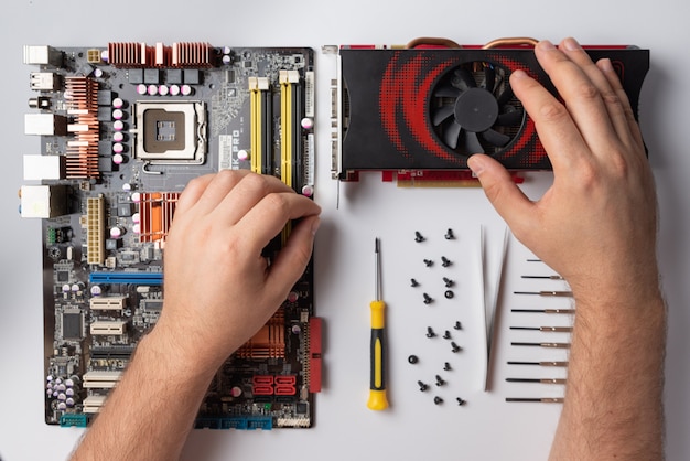 Computer details lie on a white background and male hands close-up