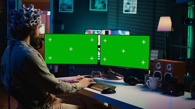 コンピュータエンジニアが緑の画面のPCを使用してマインドアップロードプロセスを開始します