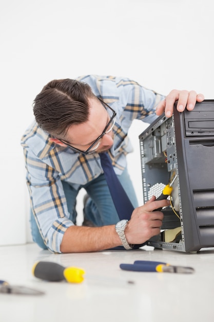 Computer engineer working on broken console with screwdriver