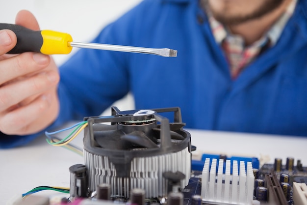 Computer engineer working on cpu with screwdriver