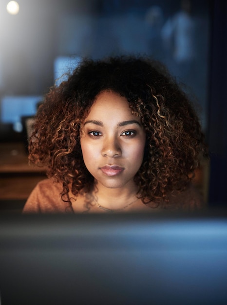computer face and night with woman coder in office for web development deadline coding programming and software with confident programmer in workplace for cyberspace internet or online system