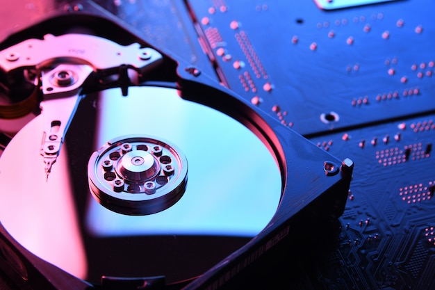 Компьютер Жесткие диски HDD, SSD на печатной плате, стол материнской платы. Крупный план. С красно-синей подсветкой.