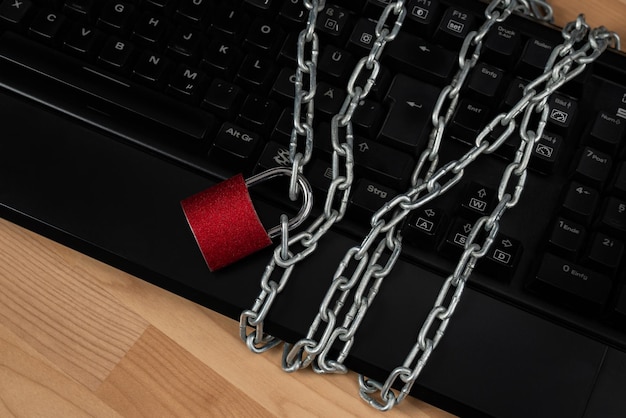 The computer keyboard is wrapped with a metal chain with a lock