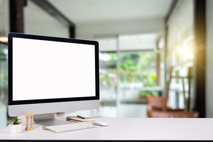 Computer Keyboard and mouse with desk on the table, Workspace with blank screen coffee cup,warm colours sun light.