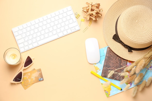 Computer keyboard with map, passport, credit cards and female accessories on color