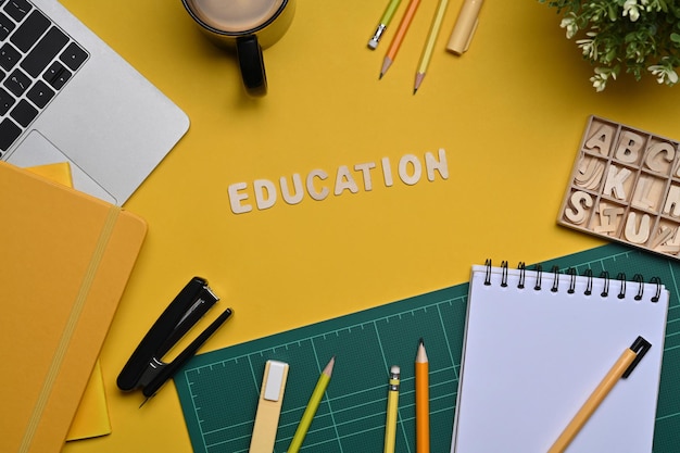 Photo computer laptop and stationery on yellow background. back to school concept.