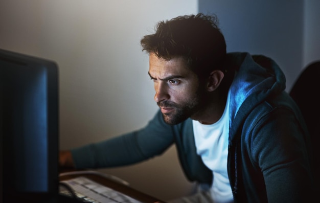 computer man or hacker at night for cyber security coding software and programming malware technology male person or developer in home office for phishing ransomware and digital crimes