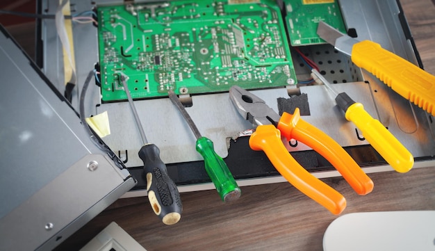 Computer monitor and repairing tools on the wooden desk