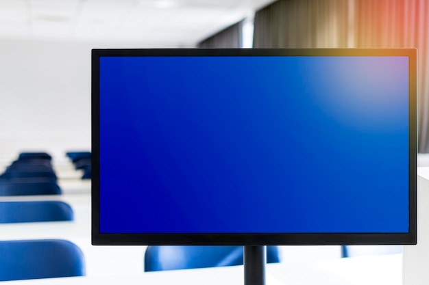 背景にブルー スクリーンの空の教室とコンピューター モニター遠隔教育の概念