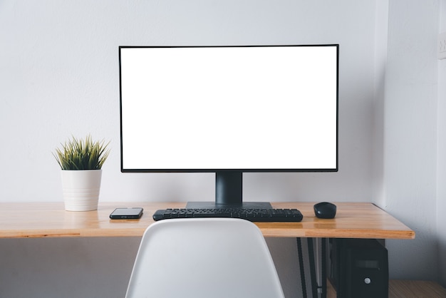 Foto monitor del computer con schermo bianco vuoto sulla scrivania da lavoro con tastiera mouse wireless