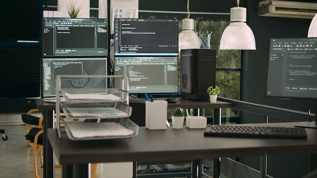 Computer monitors showing parsing code in empty it agency office, security system compiling data algorithms in background. Artificial intelligence servers cloud computing in data room.