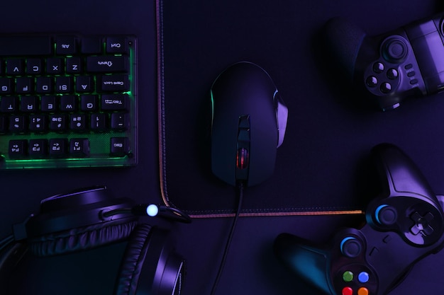 computer mouse rgb keyboard game controllers and headset on black background top view