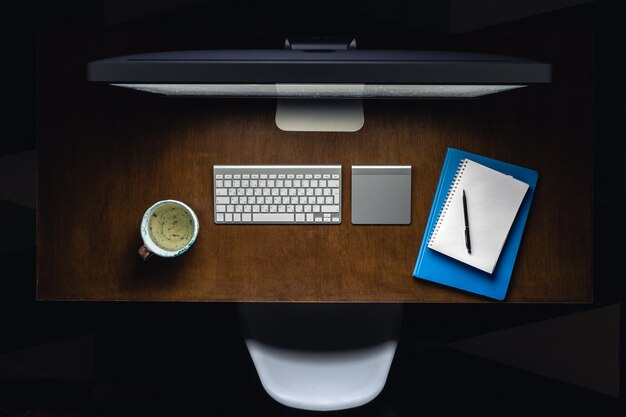 Computer notepads and a cup of tea on the desktop at night top view