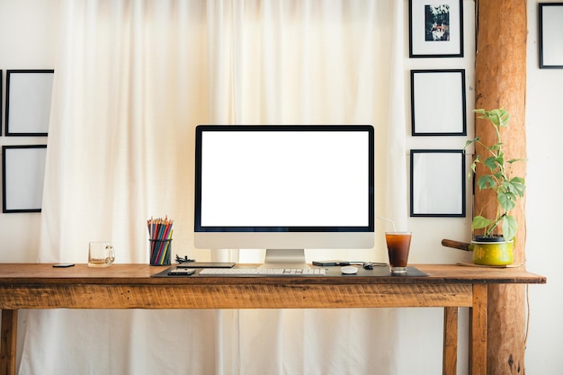 Computer op een bureau thuis met witte gordijnen houten bureau in huis