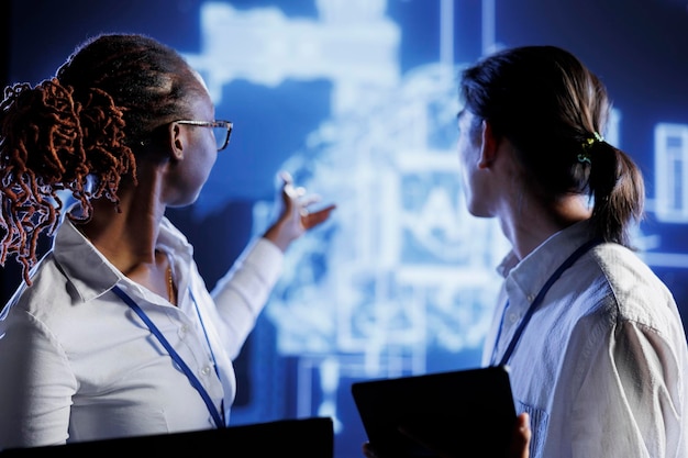 computer operators thinking of ways to use ai cognitive computing to extract usable information from complex data. server room employees implement artificial intelligence to process massive datasets