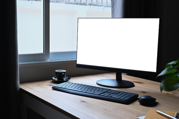 Foto computer pc tazza da caffè e pianta d'appartamento su tavola di legno display vuoto per il montaggio del display grafico