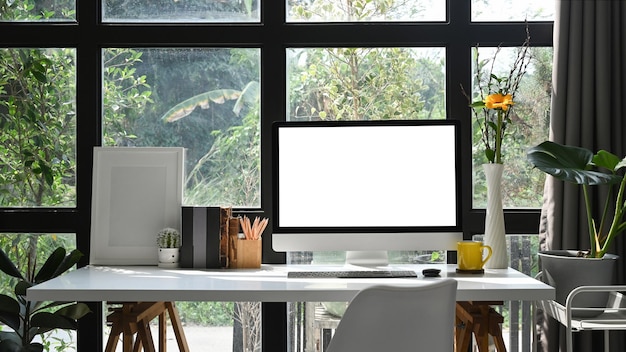 Computer pc empty picture frame and potted plant on white table