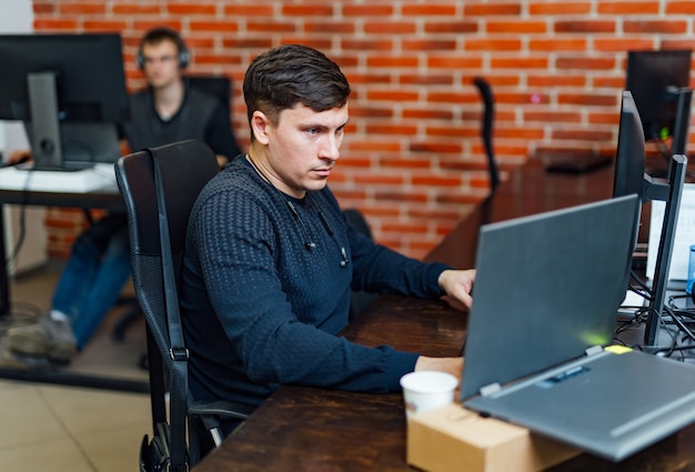 Computer programmer writing program code on computer in office. Programming.