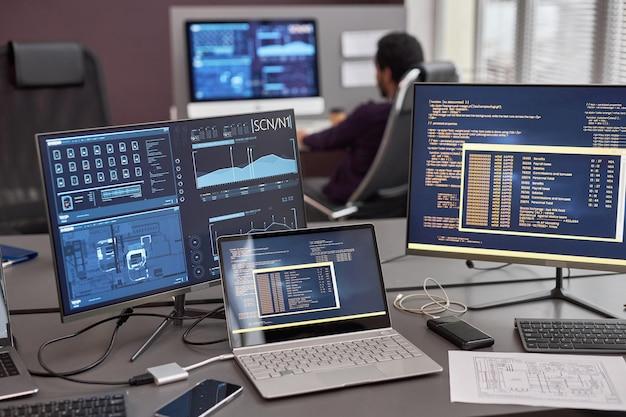 Computer screen with code lines and data on desk in IT development office