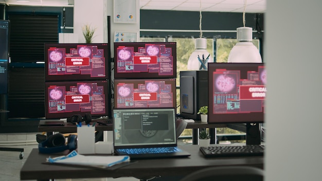 computer screens running hacking alert security breach in empty software it agency office, critical error message flashing on screen with data algorithms. hacked system server malfunction.