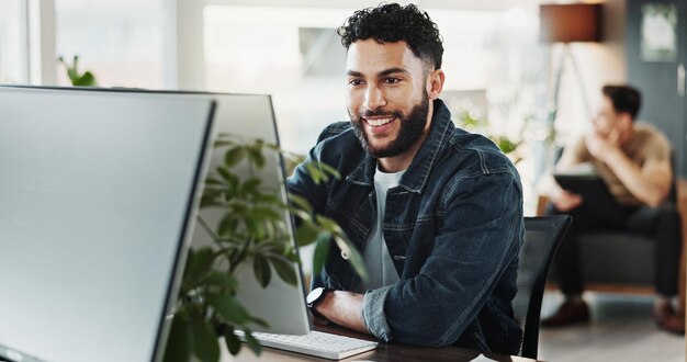 computer smile and web development with man in creative workplace for coding or design cybersecurity programming and system infrastructure with happy employee person in office as website developer
