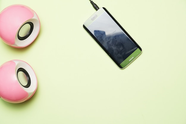 Computer speakers and smart phone on a green background. flat lay. flat design