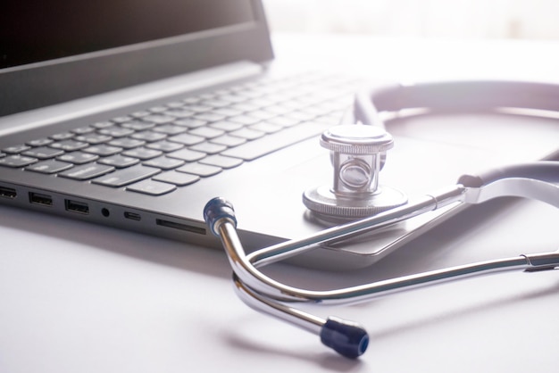 The computer and stethoscope pen lie on the table the concept of health insurance