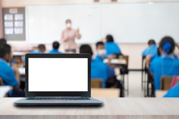 Computer on the table blur image of the children classroom