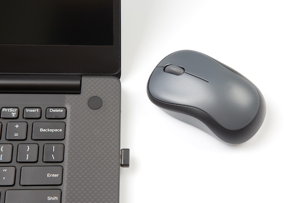 Photo computer wireless mouse next to a laptop on a white table closeup electronic personal industry