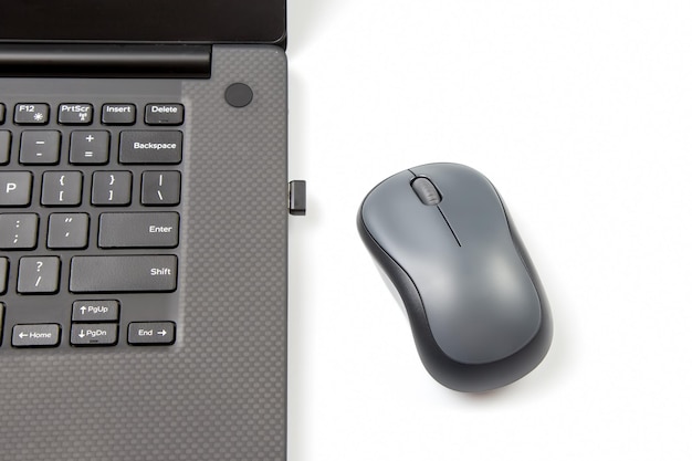 Photo computer wireless mouse next to a laptop on a white table closeup electronic personal industry