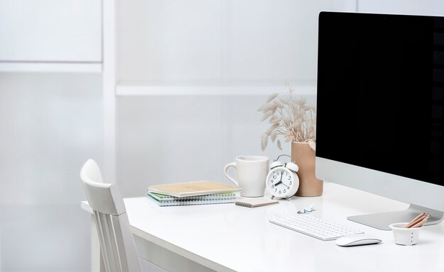 Photo computer with blank screen and houseplant