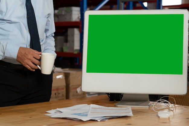 Computer with green screen display in warehouse storage room