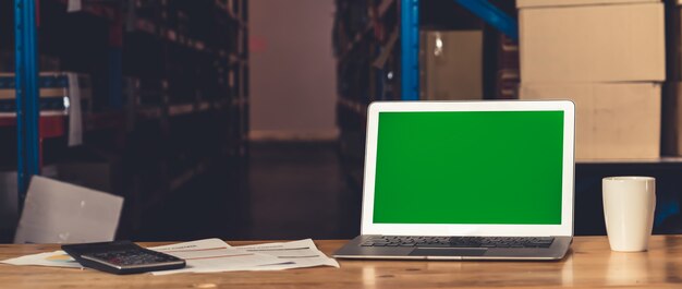 Computer with green screen display in warehouse storage room