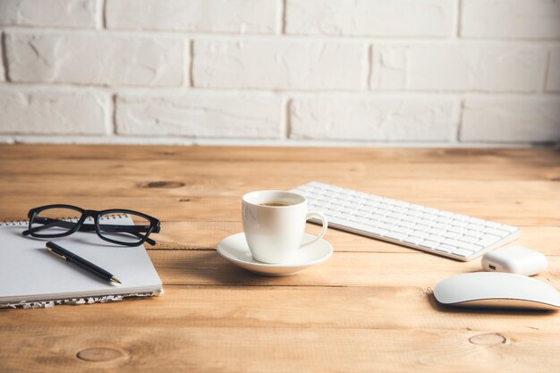 Photo computer with notepad and coffee on table