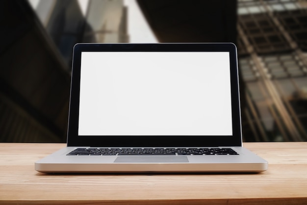 Компьютер с белым экраном на столе с размытым фоном. Концепция технологии.