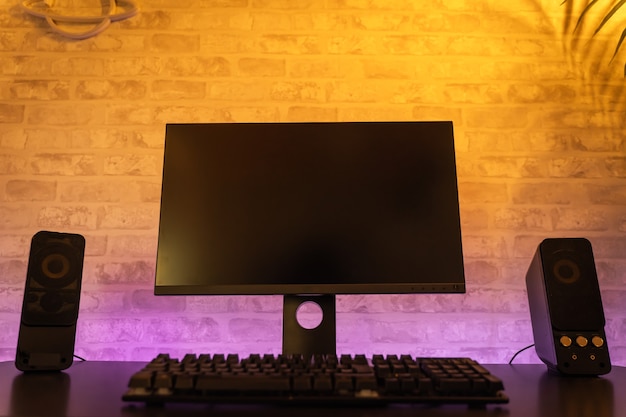 Computergamerwerkruimte met zwart schermmonitor met neons en kleurrijke lichten gamer rig