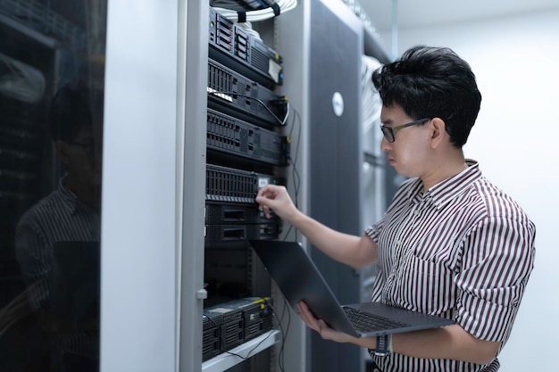 Computeringenieur stelt een netwerk op in de serverruimte System Maintenance Technician Mannelijke ingenieur werkt in de serverkamer in een modern datacentrum