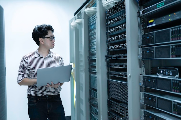 Computeringenieur stelt een netwerk op in de serverruimte System Maintenance Technician Mannelijke ingenieur werkt in de serverkamer in een modern datacentrum