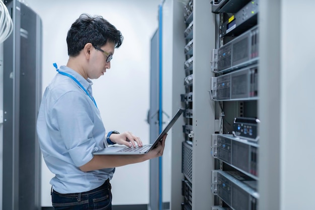 Computeringenieur stelt een netwerk op in de serverruimte System Maintenance Technician Mannelijke ingenieur werkt in de serverkamer in een modern datacentrum